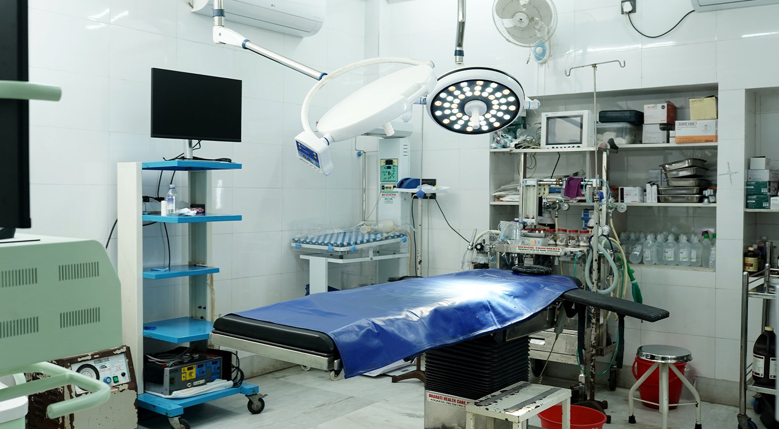 A modern operation theatre with surgical lights, equipment, and an operating table inside a nursing home.