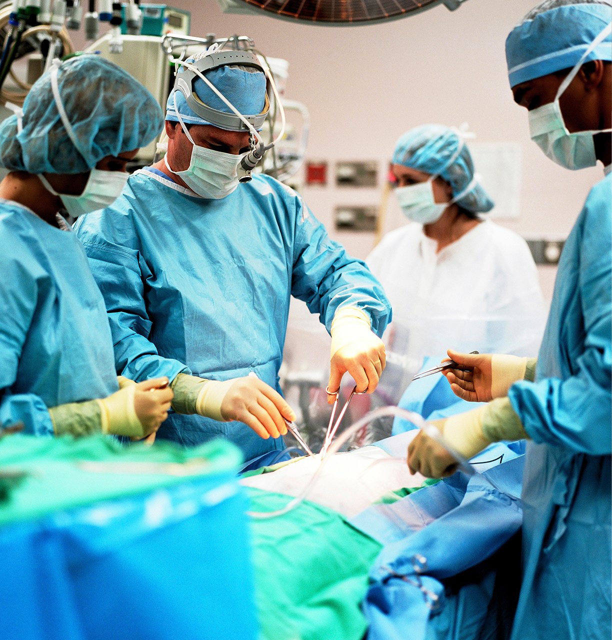 Surgeons performing a surgical procedure with medical instruments under sterile conditions in a nursing home.