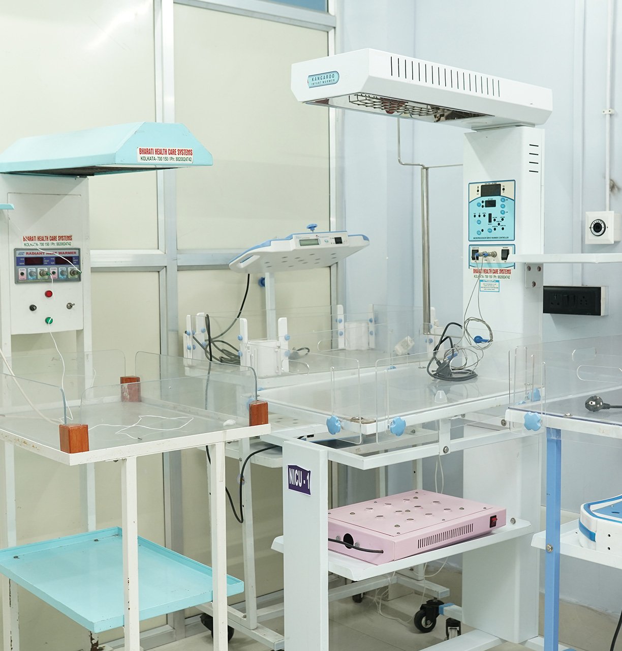 Neonatal care equipment and infant warmers arranged in a nursing home NICU setup.