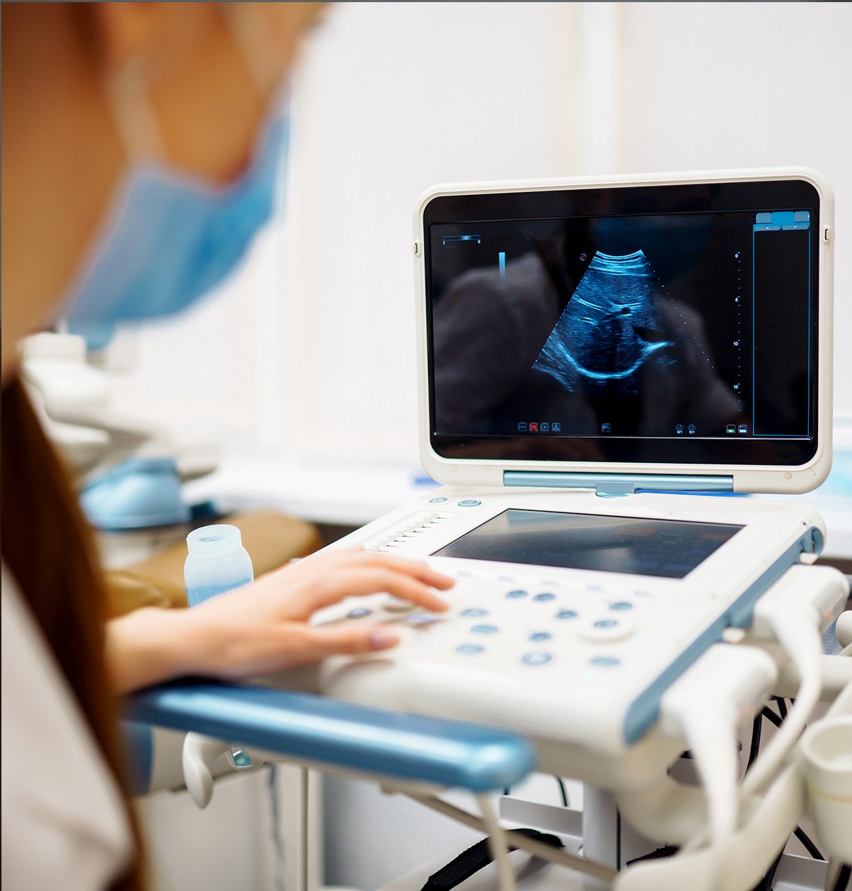 A technician performing an ultrasound scan using diagnostic equipment in a nursing home.